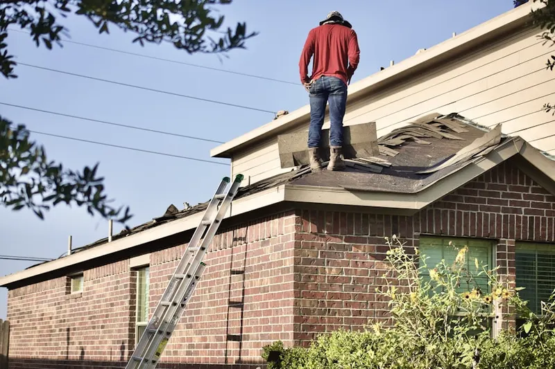 Professional roofer working on a residential roof in Mill Neck